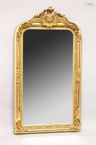A LARGE ORNATE GILT FRAMED ARCH TOP MIRROR, the top with mou...