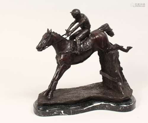 A CAST BRONZE GROUP DEPICTING A HORSE AND JOCKEY JUMPING A F...