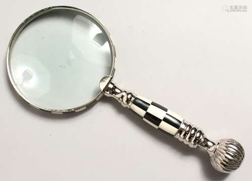 A MAGNIFYING GLASS with chequered handle.