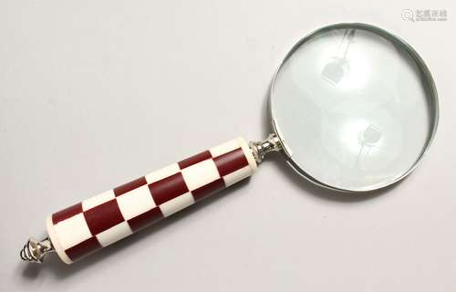 A MAGNIFYING GLASS with chequered handle