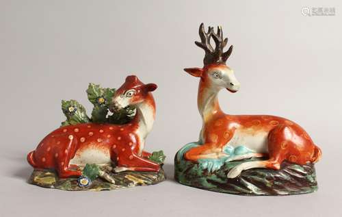 TWO LARGE STAFFORDSHIRE SEATED DEER with spots on rustic bas...