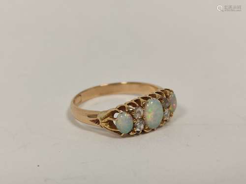 Gold ring with three opals and diamond points, probably 9ct....