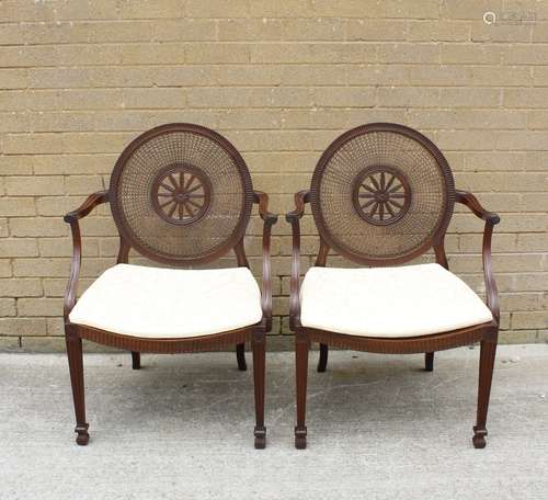 A pair of Sheraton revival mahogany open elbow chairs, the b...