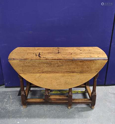 Antique oak drop leaf table raised on turned supports