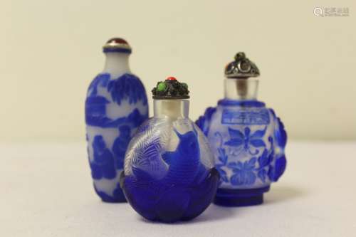 Three Chinese blue overlay glass snuff bottles, one bearing ...