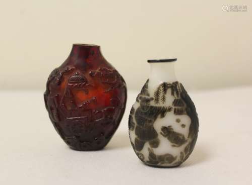 Two antique Chinese snuff bottles to include a dark red carv...