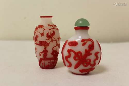 Two Chinese glass snuff bottles to include a red glass overl...