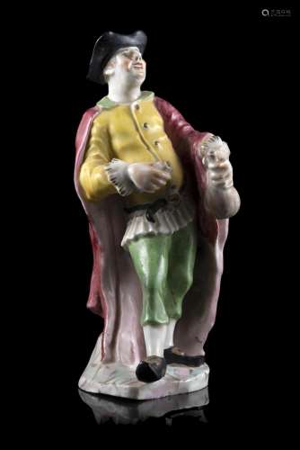 A polychrome porcelain figure representing a gentleman holdi...