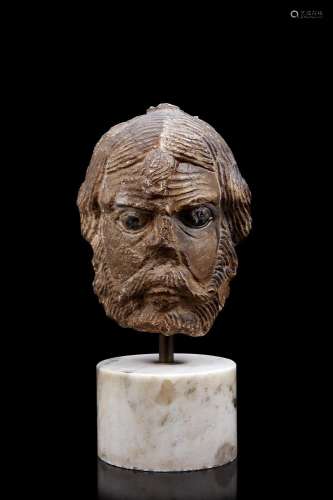A 16th-century stone sculpture depicting a male face (h. cm ...