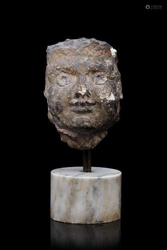 A stone sculpture depicting a face (h. cm 13) on marble base...