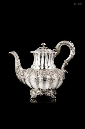 An embossed silver teapot decorated with floral motifs. Bone...