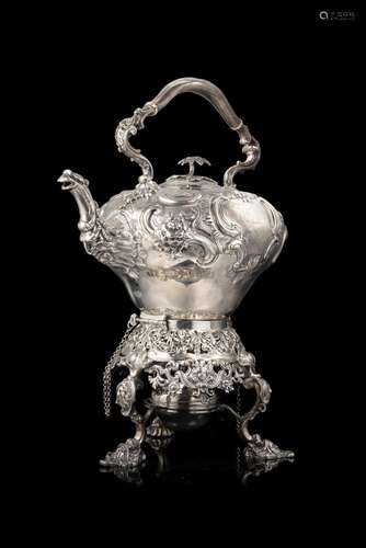 An embossed silver samovar engraved with swirls and spirals....