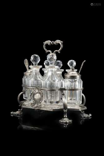 A silver cruet with glass ampoules and two little spoons wit...
