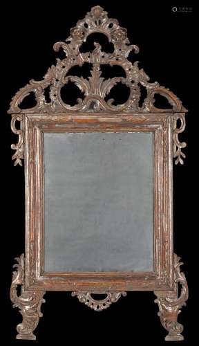 An 18th-century silvered carved wooden mirror (cm 157x86) (d...