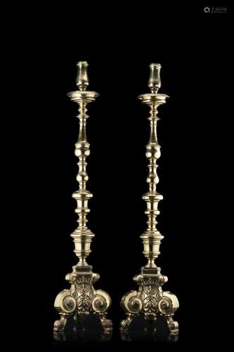 A pair of gilt bronze tripod candle-holders inscribed with c...