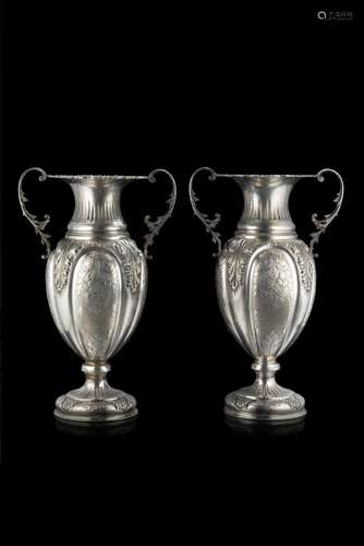 A pair of embossed silver vases engraved with plant motifs. ...