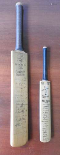 TWO SIGNED MINIATURE CRICKET BATS, the larger bat bearing th...