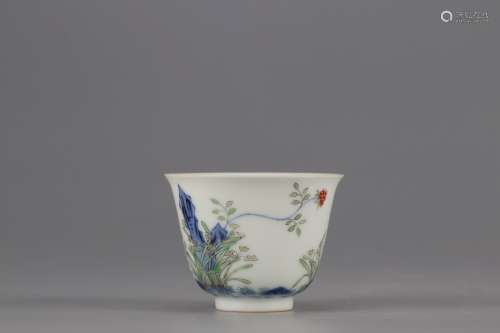 AN OVERGLAZED CUP PAINTED WITH FLOWERS