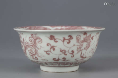 AN UNDERGLAZED RED BOWL WITH DRAGON PATTERNS