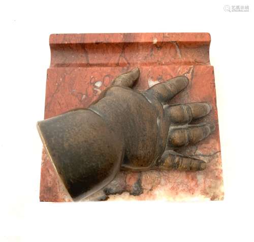 Une main d'enfant moulée en bronze à patine brune reposant s...
