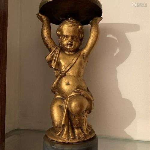 Statuette en métal doré représentant un putto à genoux les b...