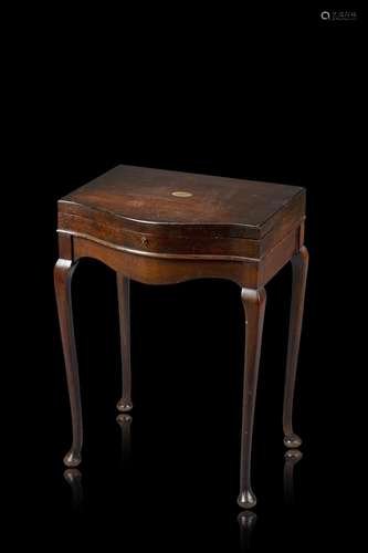 A wooden table with an extendable top hiding a silver and iv...