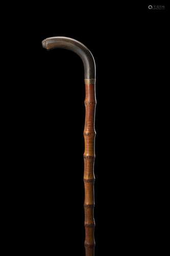 An early 20th-century bamboo walking stick with horn handle....