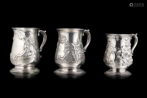 A lot comprising three different embossed silver jugs, engra...