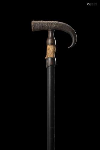 A 19th-century ebony walking stick with horn and pelt handle...