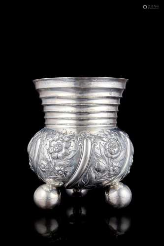 An embossed silver vase decorated with floral motifs. London...