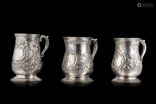 A lot comprising three different embossed silver jugs, engra...