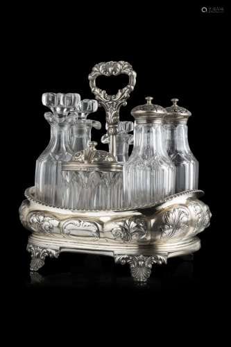 An embossed silver cruet with seven crystal ampoules. London...