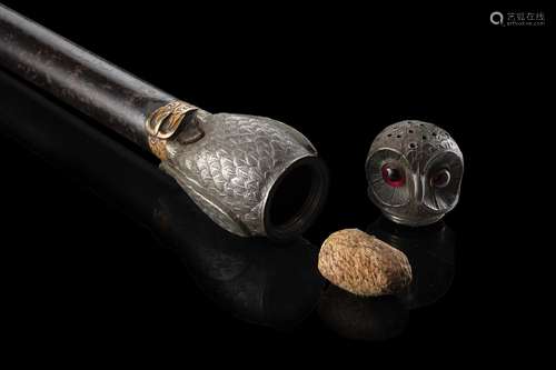 An early 20th-century ebony walking stick with metal owl sha...