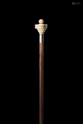 A wooden walking stick with a game-composed ivory knob. Silv...