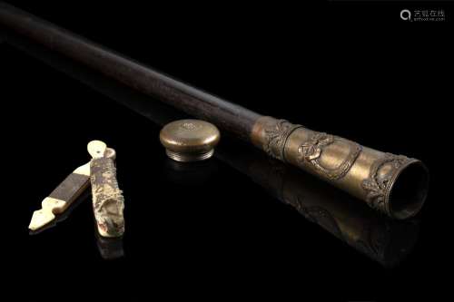 An ebonised wood walking stick with a gilt brass handle hidi...