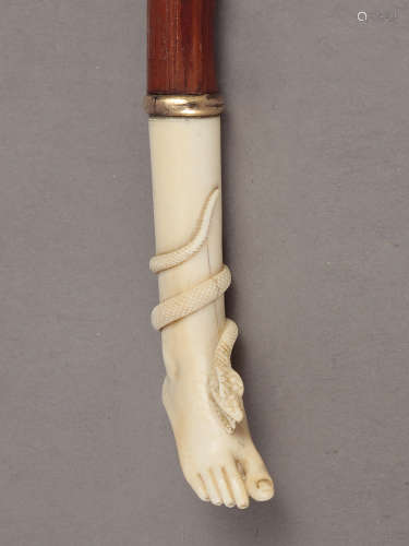An early 20th century walking stick with a carved ivory hand...