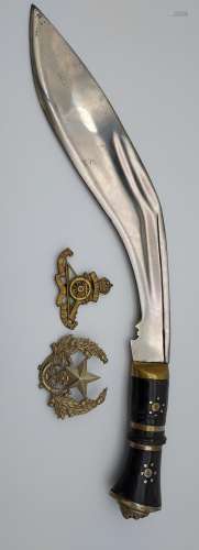Kukri knife together with two military cap badges.