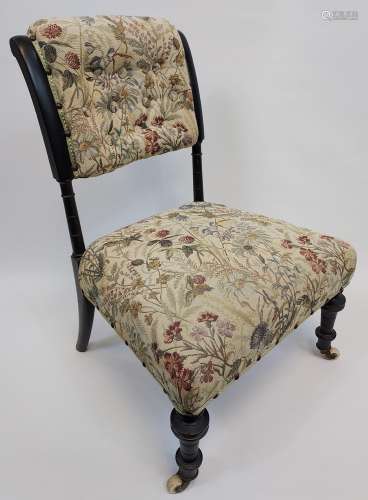A 19th century nursing chair. Supported on turned legs. Ebon...