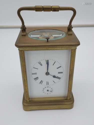 A large antique Brass and bevel glass carriage clock. In a w...