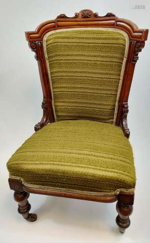 A 19th century bedroom chair designed with a carved wooden f...