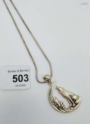 A silver necklace in the form of a dog howling at the moon [...