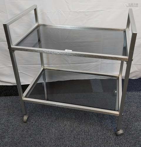 A Mid century stainless steel and black glass two tier troll...