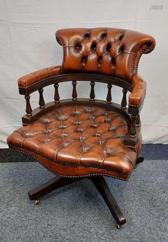 A Brown leather Chesterfield Captains chair.