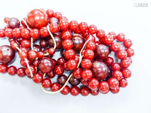 A group of loose simulated cherry amber beads and one other ...