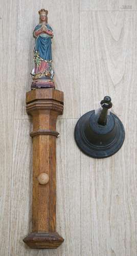 An early hand bell and a religious figure on an oak pilaster...