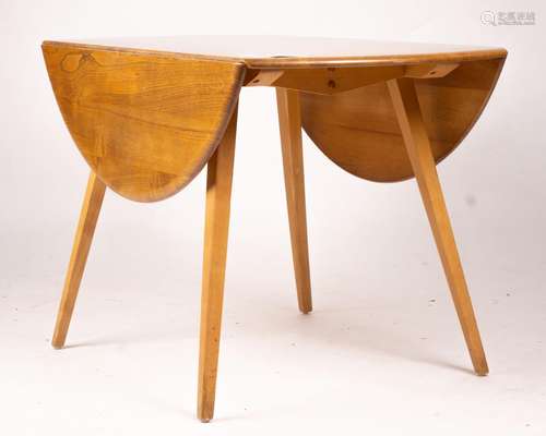 An Ercol light elm and beech circular drop leaf dining table...