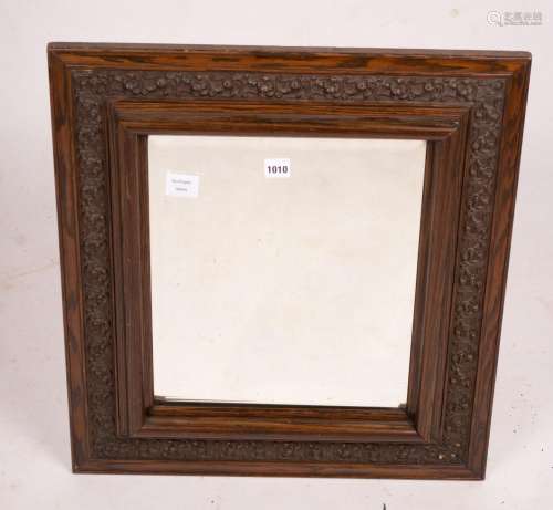 An early 20th century carved oak rectangular wall mirror, wi...