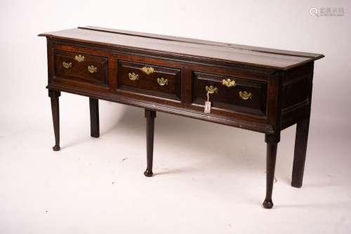 An 18th century oak low dresser on pole turned legs and pad ...
