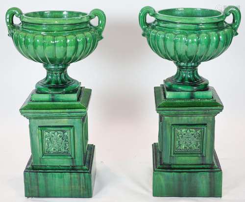 A pair of large dark green glazed terracotta fluted urns, ra...