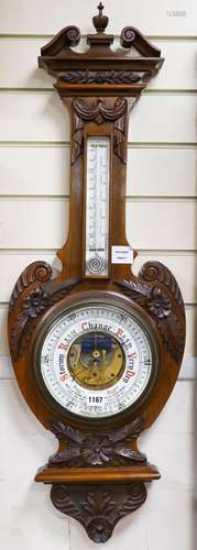 An Edwardian carved walnut cased aneroid barometer and therm...